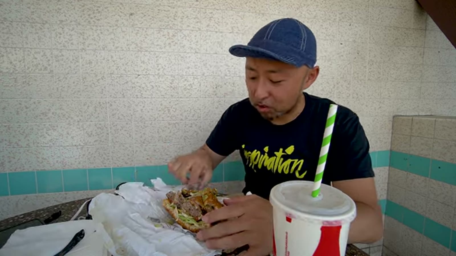巨大バーガーを持ち上げて驚く一コマ