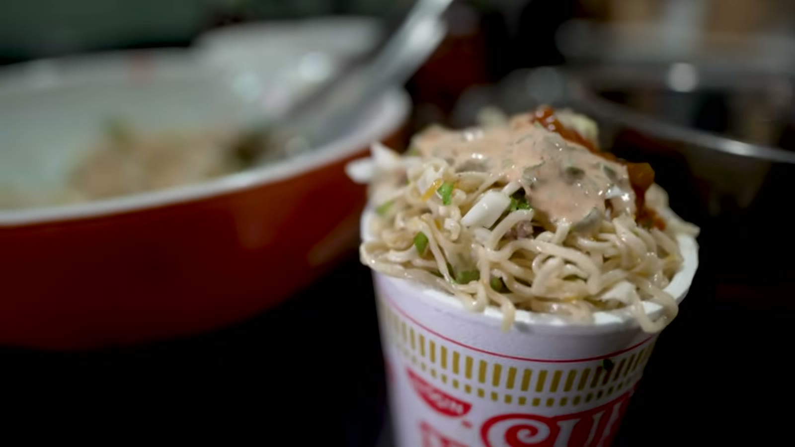 麺と具材をボウルで混ぜ合わせる場面