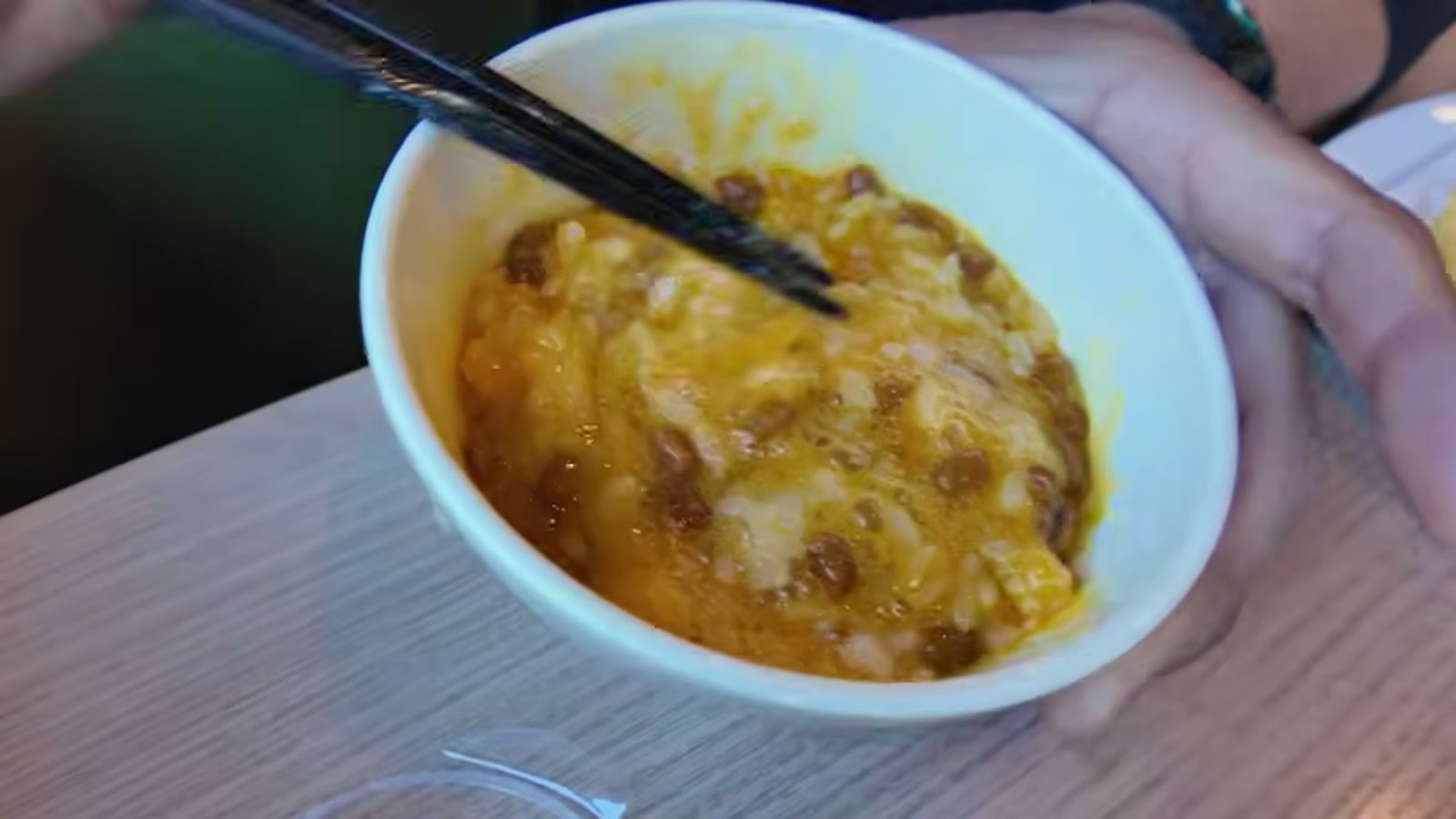 朝食に納豆と豆腐をのせていく場面