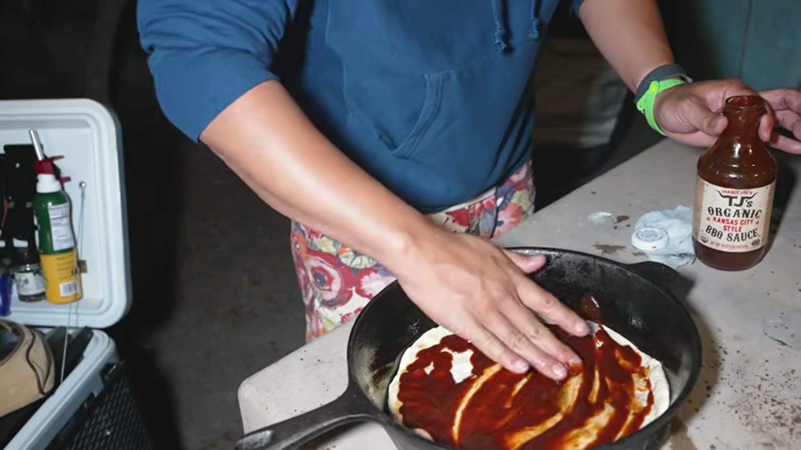 手でピザ生地をゆっくり伸ばす作業
