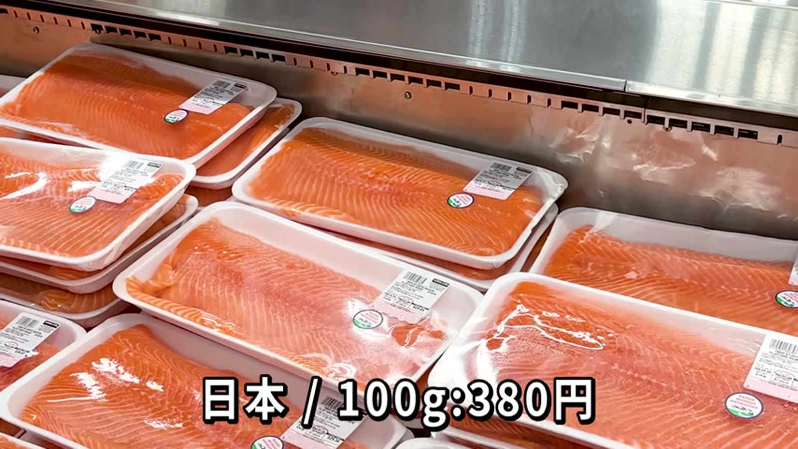サーモンのパッケージを手に値段を説明